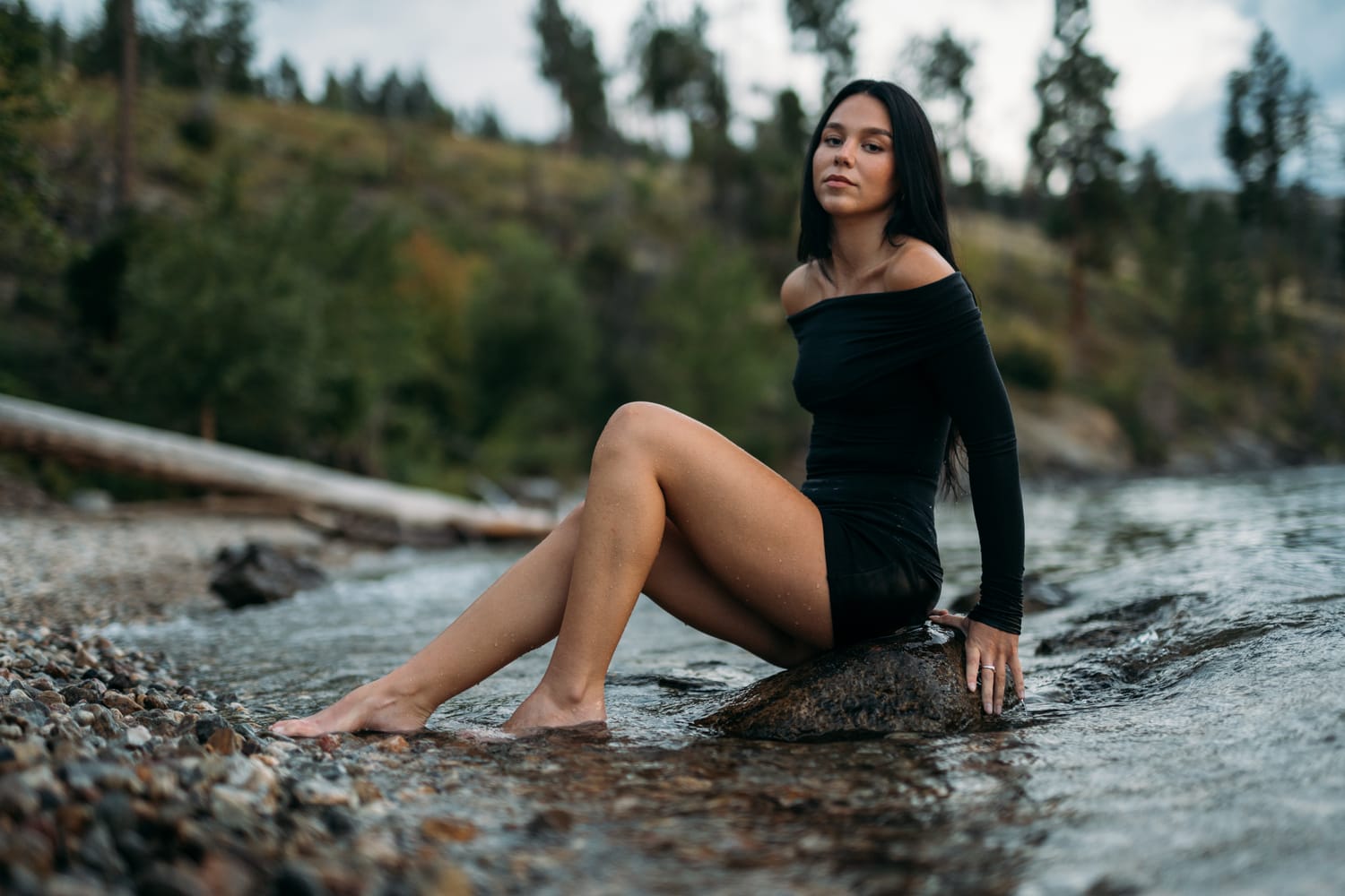 Shaylin seated in water at Bertram Creek in a black dress